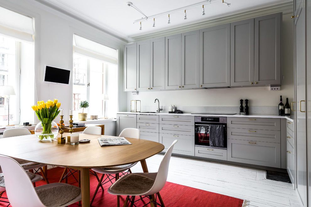 Inspiration for a scandinavian l-shaped painted wood floor and white floor eat-in kitchen remodel in Stockholm with shaker cabinets, gray cabinets, gray backsplash, black appliances and no island