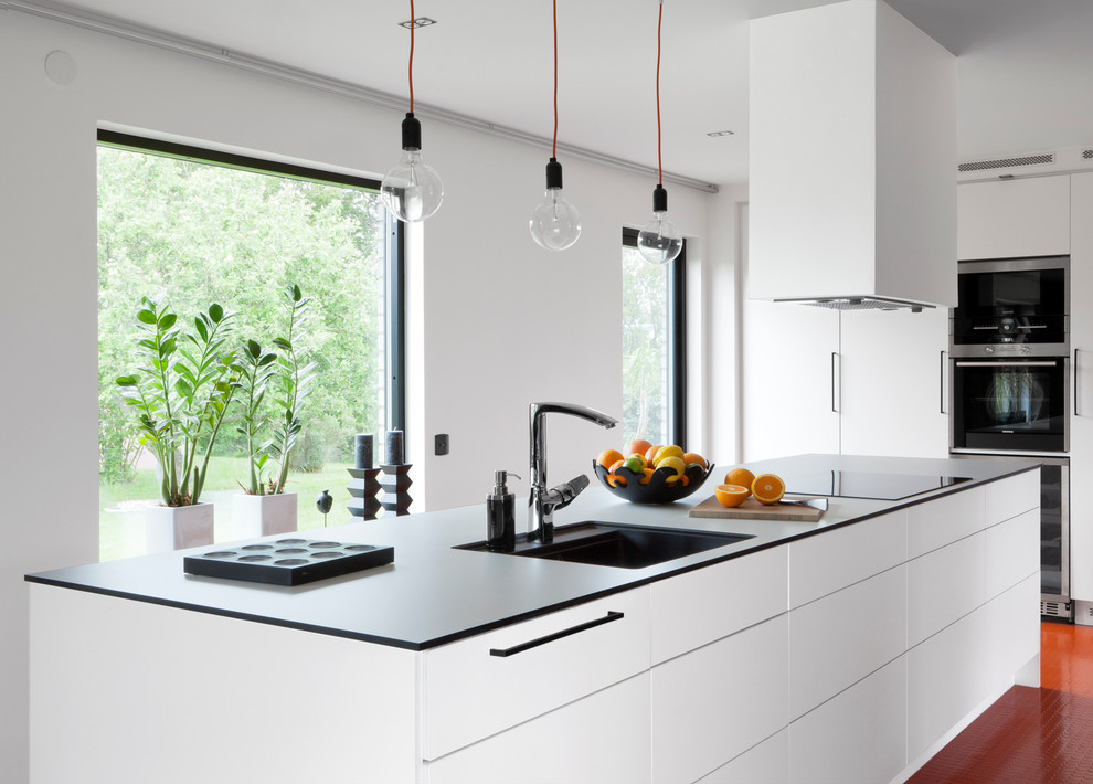 Example of a mid-sized trendy single-wall kitchen design in Orebro with a single-bowl sink, flat-panel cabinets, an island and stainless steel appliances
