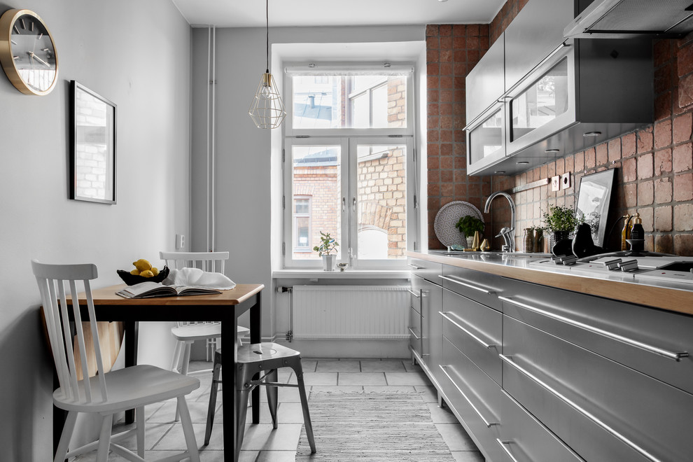 Inredning av ett minimalistiskt litet linjärt kök och matrum, med en enkel diskho, släta luckor, grå skåp, träbänkskiva, stänkskydd i tegel, rostfria vitvaror, marmorgolv och vitt golv