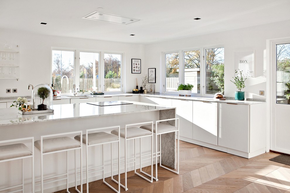 Esempio di una cucina design con ante lisce, ante bianche, top in marmo, parquet chiaro e pavimento beige