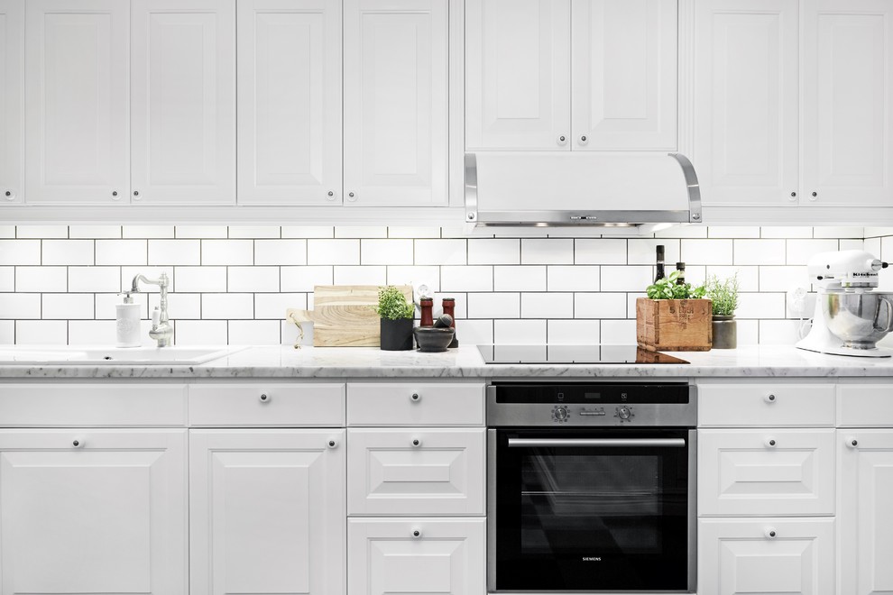 Foto på ett avskilt, mellanstort vintage linjärt kök, med skåp i shakerstil, vita skåp, marmorbänkskiva, vitt stänkskydd, stänkskydd i keramik och rostfria vitvaror