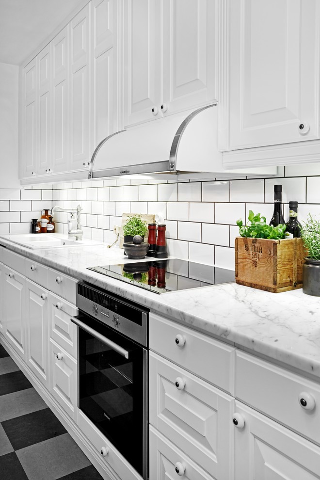 Klassisk inredning av ett avskilt, mellanstort linjärt kök, med en enkel diskho, skåp i shakerstil, vita skåp, marmorbänkskiva, vitt stänkskydd, stänkskydd i keramik, rostfria vitvaror och flerfärgat golv
