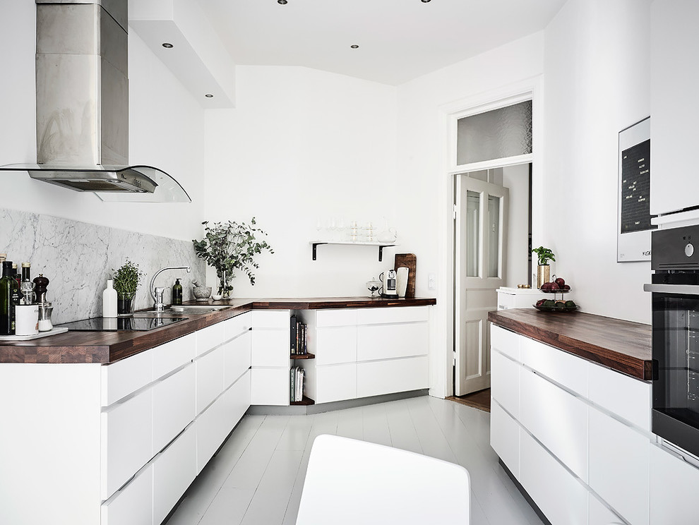 ヨーテボリにある高級な広い北欧スタイルのおしゃれなキッチン (フラットパネル扉のキャビネット、白いキャビネット、木材カウンター、塗装フローリング、アイランドなし) の写真