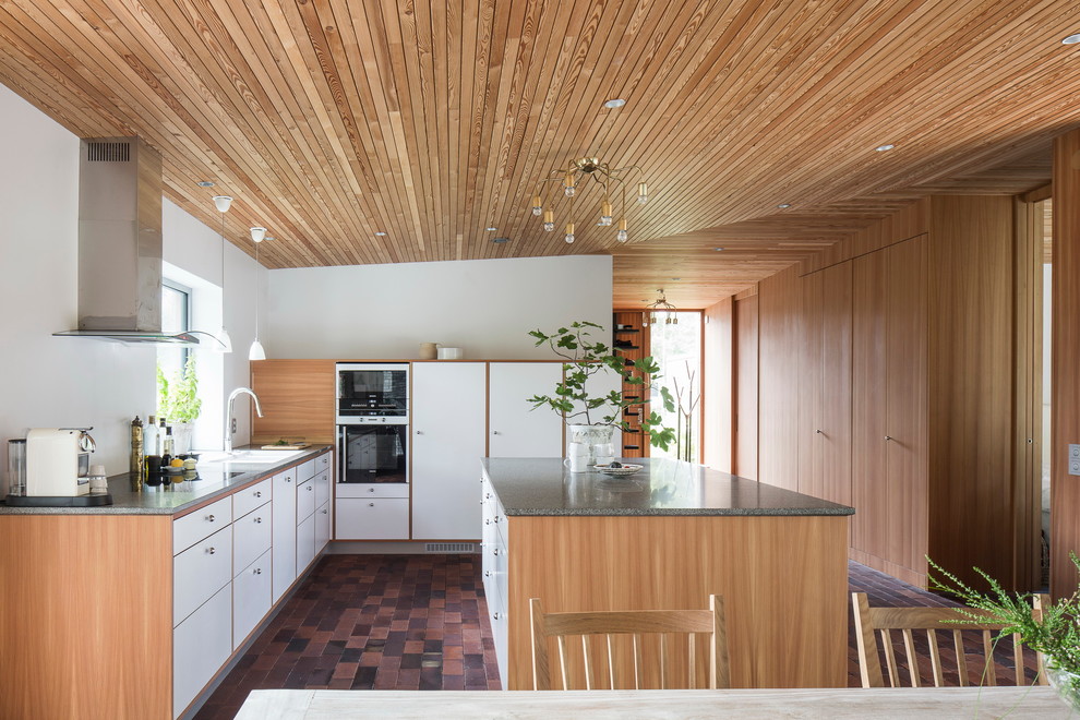 Idéer för små nordiska l-kök, med en enkel diskho, släta luckor, vita skåp, granitbänkskiva, vita vitvaror, klinkergolv i terrakotta och en köksö