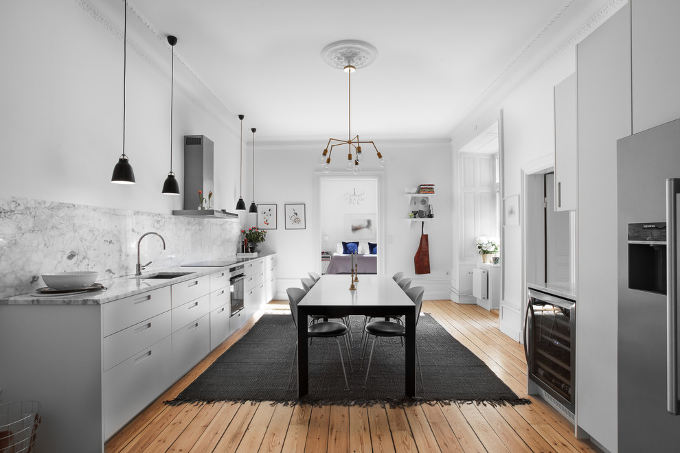 Inredning av ett skandinaviskt stort linjärt kök och matrum, med släta luckor, grå skåp, marmorbänkskiva, grått stänkskydd och stänkskydd i marmor