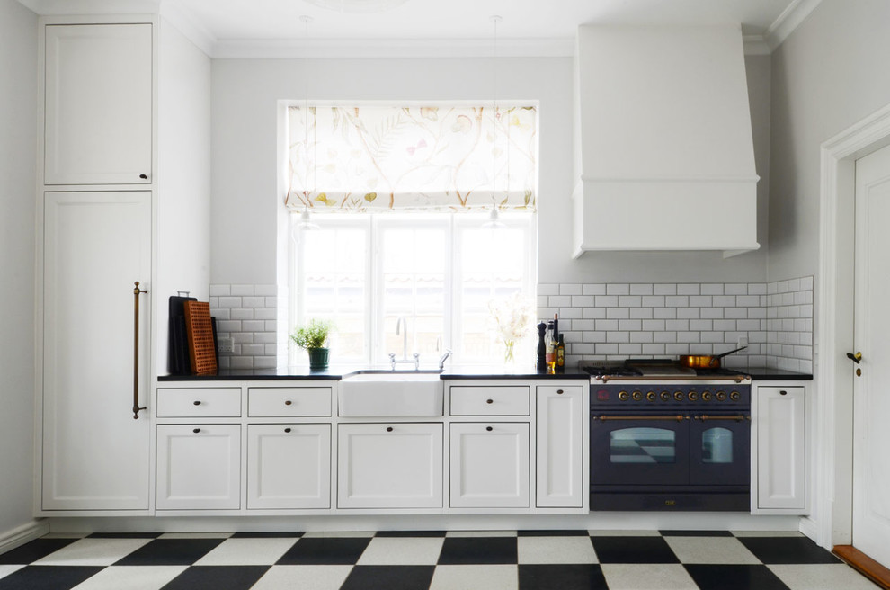 Inspiration för stora lantliga linjära kök, med en rustik diskho, svarta vitvaror och flerfärgat golv