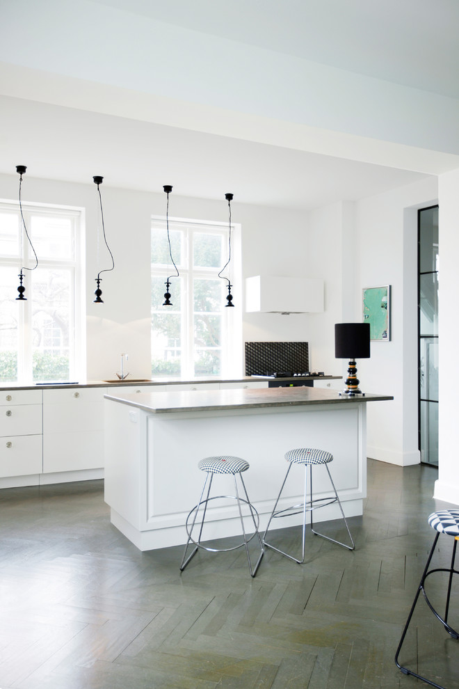 This is an example of a large scandinavian open plan kitchen in Copenhagen with white cabinets, medium hardwood flooring and an island.