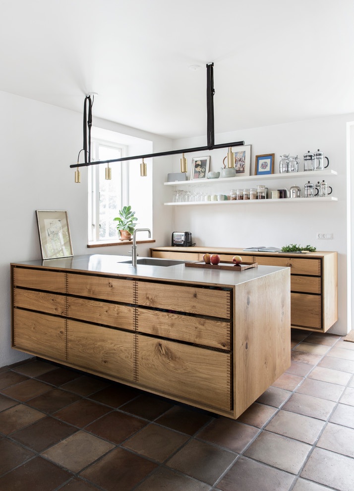 Idées déco pour une cuisine scandinave en bois brun avec un placard à porte plane, tomettes au sol, un sol marron et une péninsule.
