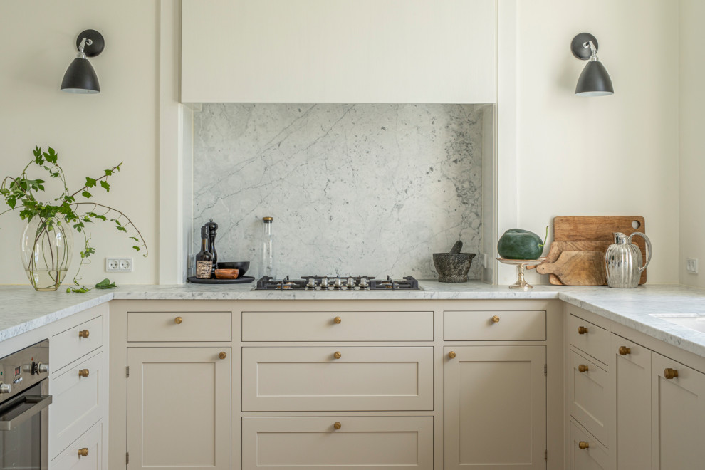 Immagine di una cucina tradizionale di medie dimensioni con ante beige, top in marmo, paraspruzzi bianco, paraspruzzi in marmo, pavimento in legno massello medio, pavimento marrone e top bianco