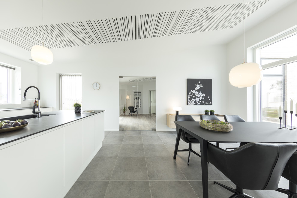 Идея дизайна: большая кухня в стиле модернизм с белыми фасадами и серым полом