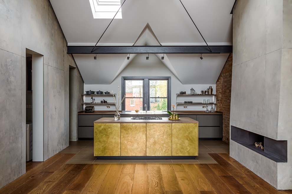 Пример оригинального дизайна: параллельная кухня-гостиная в стиле лофт с плоскими фасадами, желтыми фасадами, деревянной столешницей, островом и коричневым полом