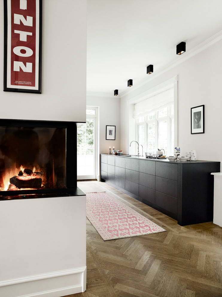 Idee per una cucina nordica con ante lisce, ante nere e pavimento in legno massello medio