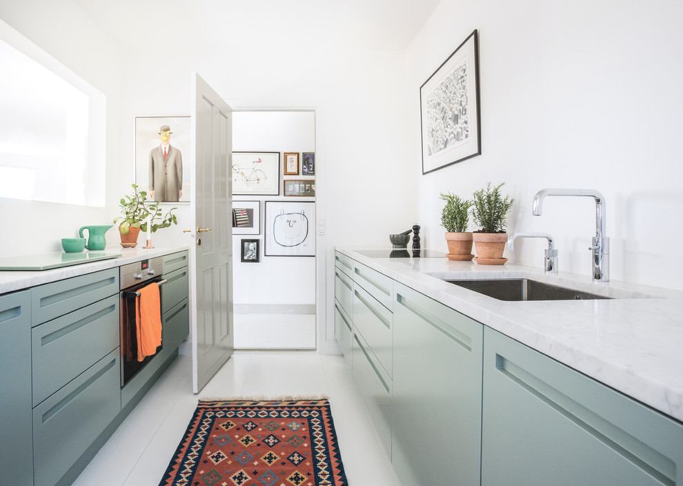 Photo of a medium sized scandinavian galley enclosed kitchen in Copenhagen with a built-in sink, flat-panel cabinets, green cabinets, marble worktops, stainless steel appliances, laminate floors and no island.