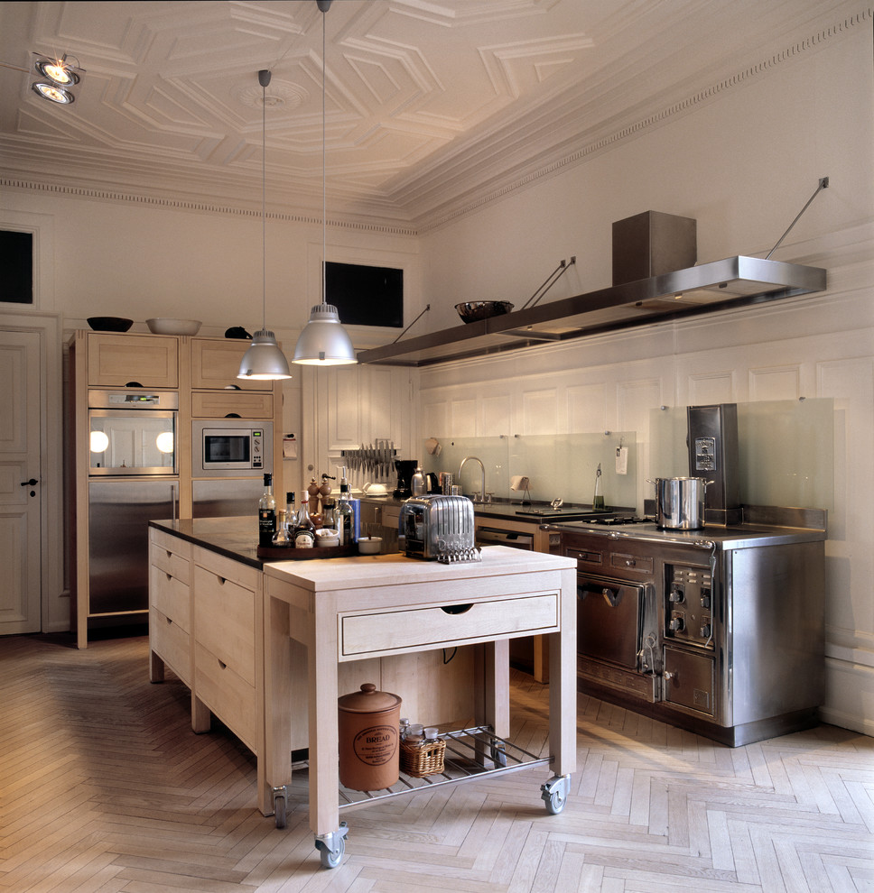 Inspiration för avskilda minimalistiska kök, med skåp i rostfritt stål och en köksö