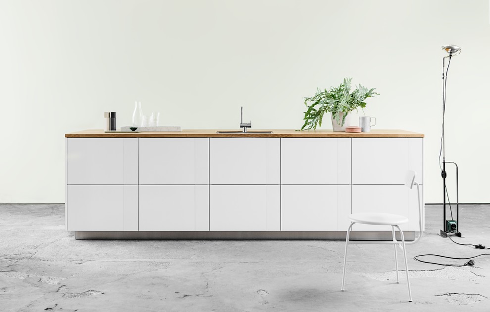 Bild på ett skandinaviskt kök, med vita skåp, träbänkskiva och en köksö