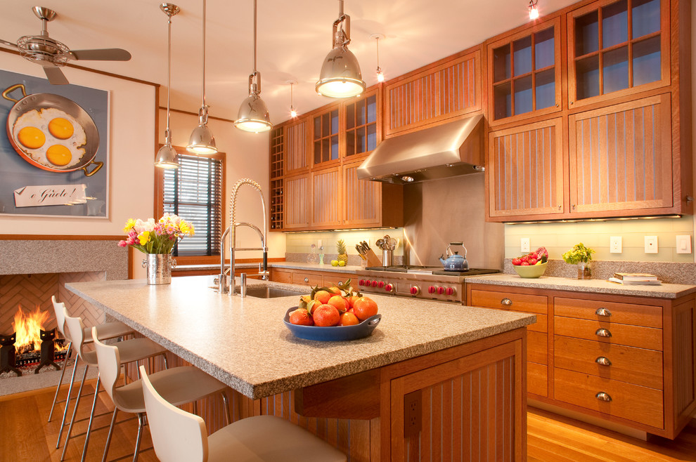 Foto på ett amerikanskt grå kök, med en undermonterad diskho, skåp i mellenmörkt trä, stänkskydd med metallisk yta, mellanmörkt trägolv, en köksö, brunt golv och luckor med infälld panel