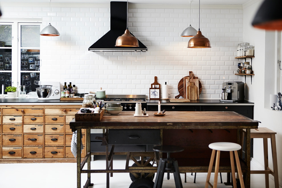 ウィルトシャーにある中くらいなインダストリアルスタイルのおしゃれなキッチン (フラットパネル扉のキャビネット、黒いキャビネット、白いキッチンパネル、サブウェイタイルのキッチンパネル、黒い調理設備) の写真
