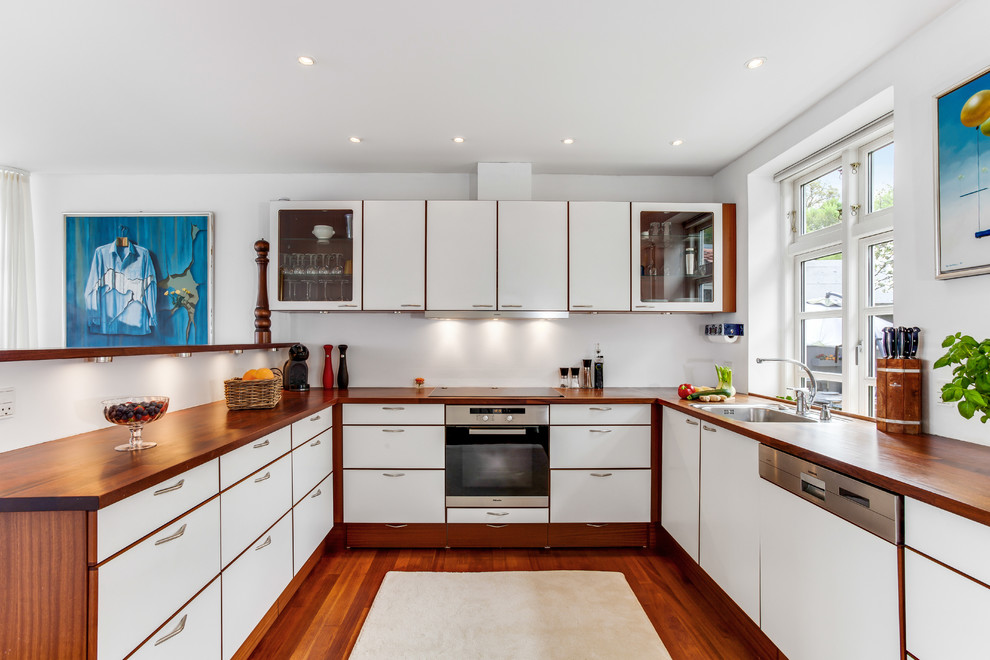 Inspiration for a medium sized modern kitchen in Miami with flat-panel cabinets, wood worktops, white splashback and dark hardwood flooring.