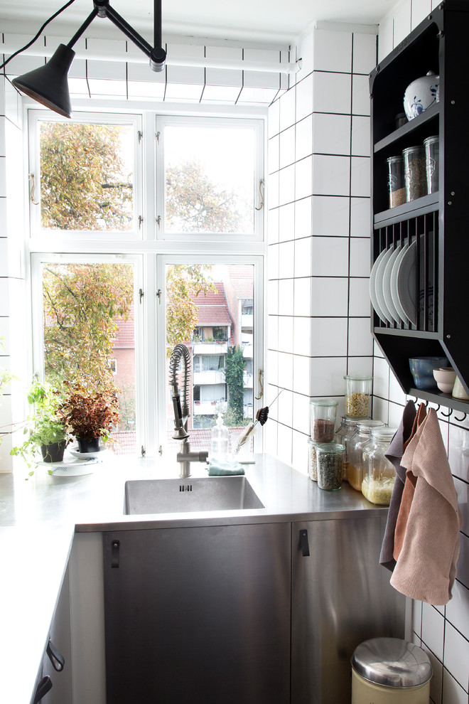 コペンハーゲンにある小さな北欧スタイルのおしゃれなL型キッチン (フラットパネル扉のキャビネット、ステンレスキャビネット) の写真
