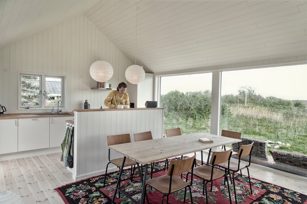 Стильный дизайн: параллельная кухня-гостиная среднего размера в скандинавском стиле с врезной мойкой, плоскими фасадами, белыми фасадами, деревянной столешницей, техникой под мебельный фасад и островом - последний тренд