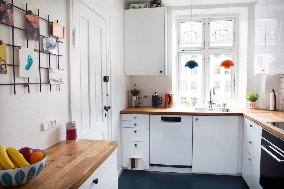 Idéer för avskilda skandinaviska brunt l-kök, med en enkel diskho, släta luckor, vita skåp, träbänkskiva och vitt stänkskydd