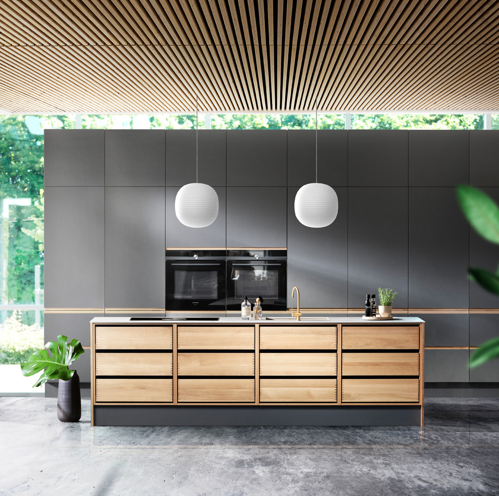 Offene Moderne Küche mit hellen Holzschränken, Kücheninsel, flächenbündigen Schrankfronten und schwarzen Elektrogeräten in Sonstige