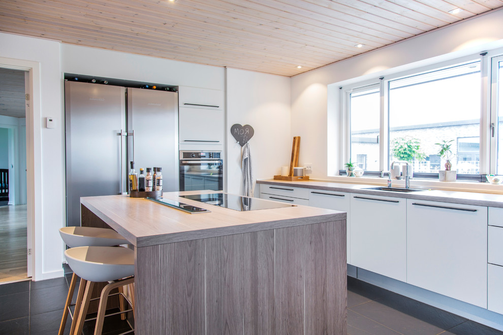 Photo of a medium sized contemporary galley enclosed kitchen in Aarhus with a double-bowl sink, flat-panel cabinets, white cabinets, wood worktops, ceramic flooring and an island.