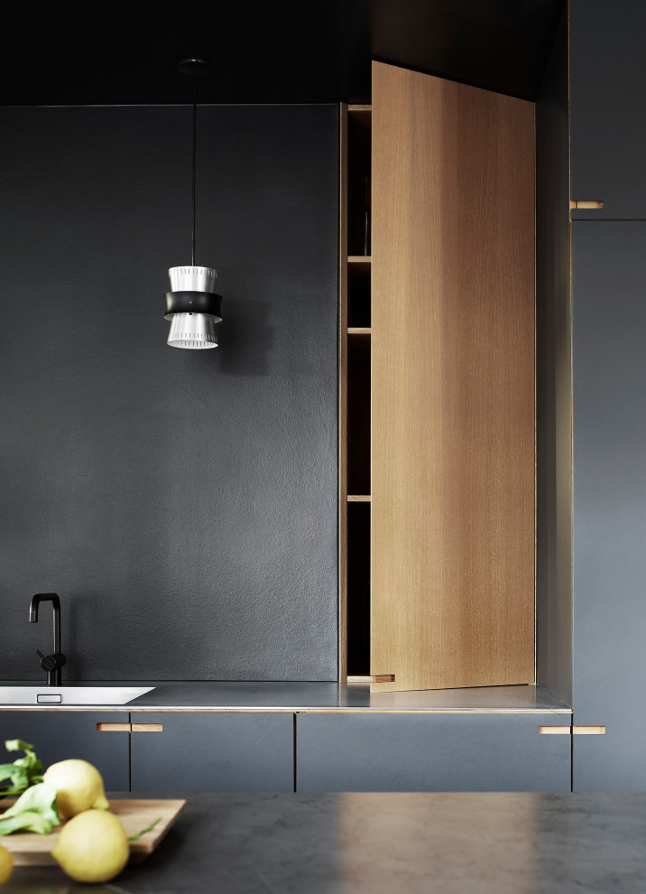 Diseño de cocina lineal nórdica de tamaño medio abierta con puertas de armario negras, encimera de mármol y una isla