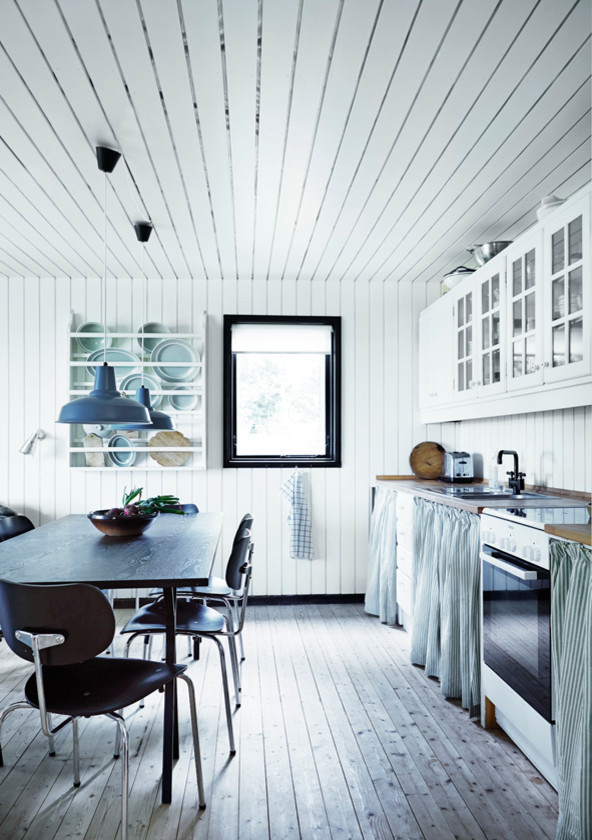 Skandinavisk inredning av ett mellanstort linjärt kök, med luckor med glaspanel och vita skåp