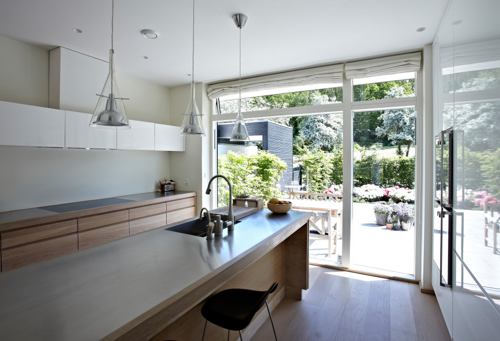 Mid-sized trendy galley kitchen photo in Copenhagen with a double-bowl sink, stainless steel countertops and an island