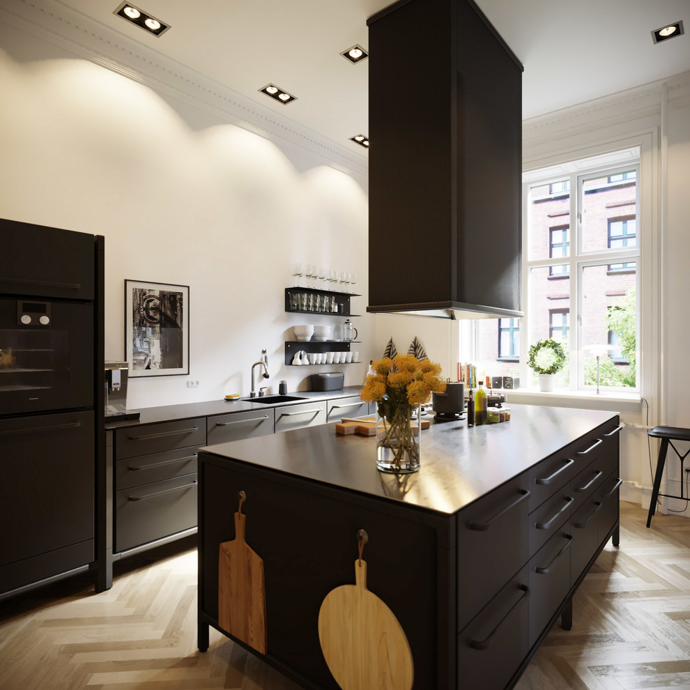 Diseño de cocina nórdica con armarios con paneles lisos, puertas de armario negras y una isla