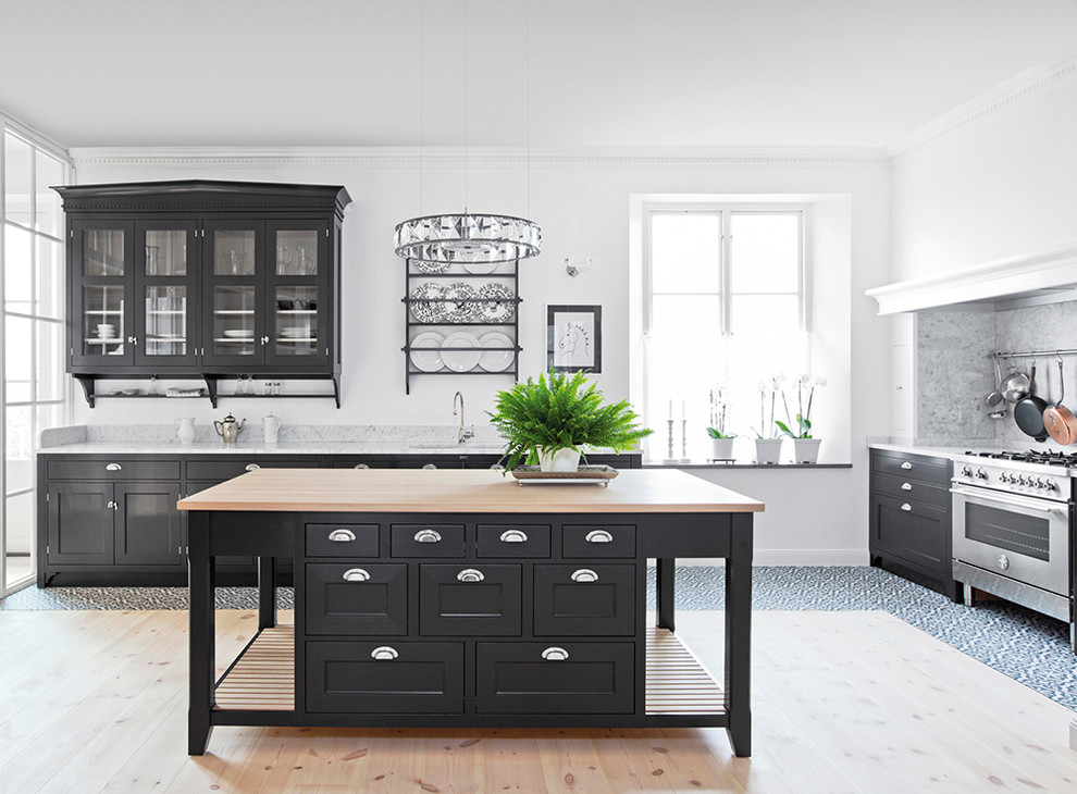 Inspiration för avskilda, stora skandinaviska l-kök, med en nedsänkt diskho, luckor med infälld panel, svarta skåp, marmorbänkskiva, grått stänkskydd, rostfria vitvaror, ljust trägolv och en köksö