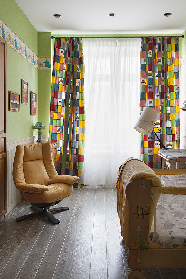 Пример оригинального дизайна: нейтральная комната для малыша в современном стиле с зелеными стенами и темным паркетным полом