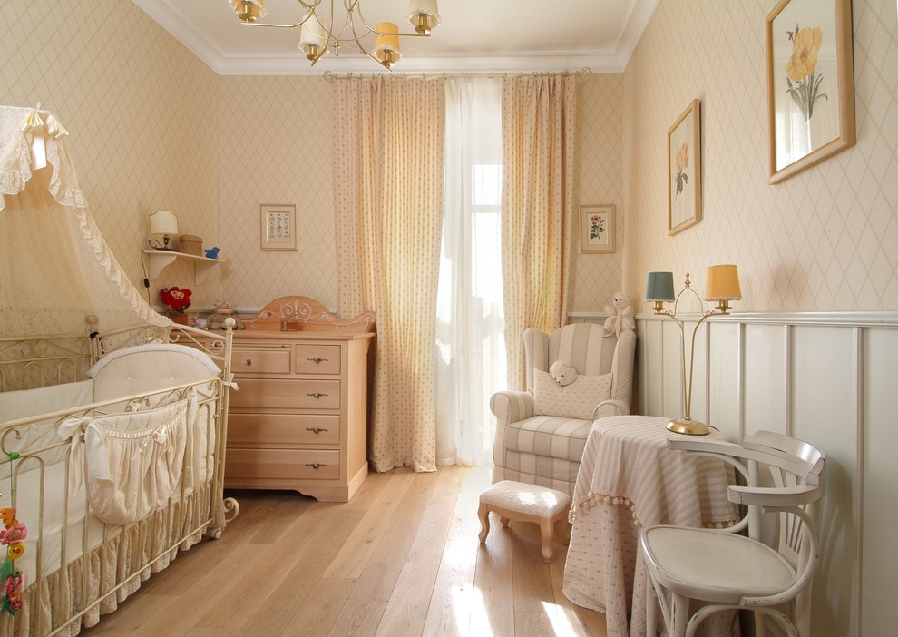 Foto de habitación de bebé niña tradicional con suelo de madera clara, paredes beige y suelo beige