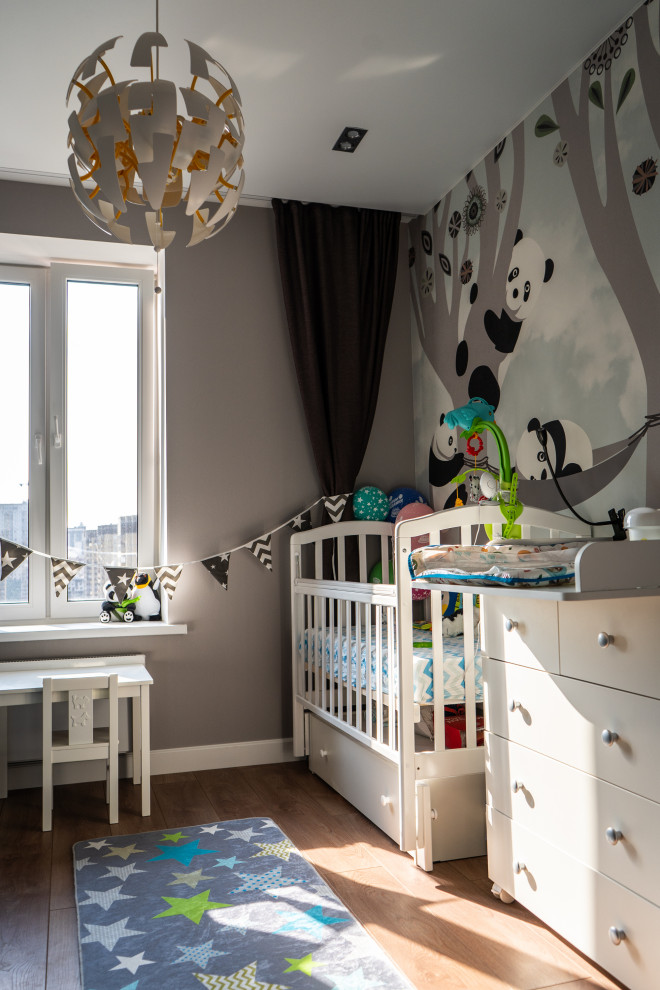 Пример оригинального дизайна: комната для малыша среднего размера в современном стиле с серыми стенами, паркетным полом среднего тона, коричневым полом и обоями на стенах для мальчика