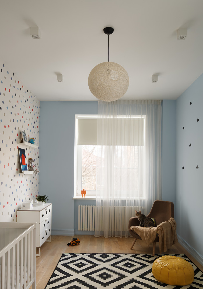 Стильный дизайн: нейтральная комната для малыша в современном стиле с синими стенами, светлым паркетным полом и коричневым полом - последний тренд