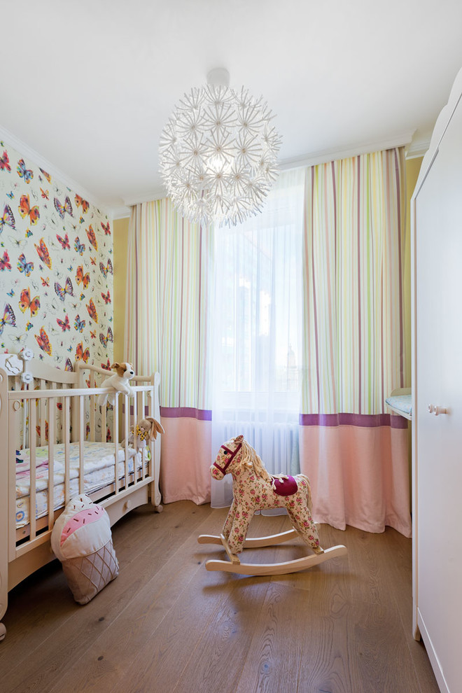 Idee per una cameretta per neonata scandinava con pareti multicolore e parquet scuro