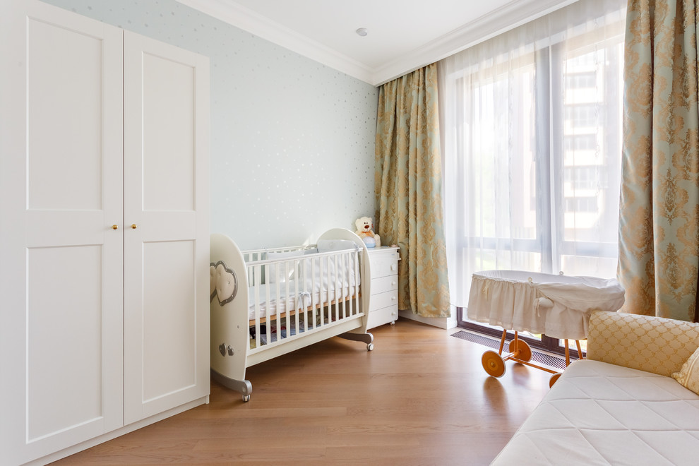Diseño de habitación de bebé neutra clásica renovada con paredes grises, suelo de madera en tonos medios y suelo marrón
