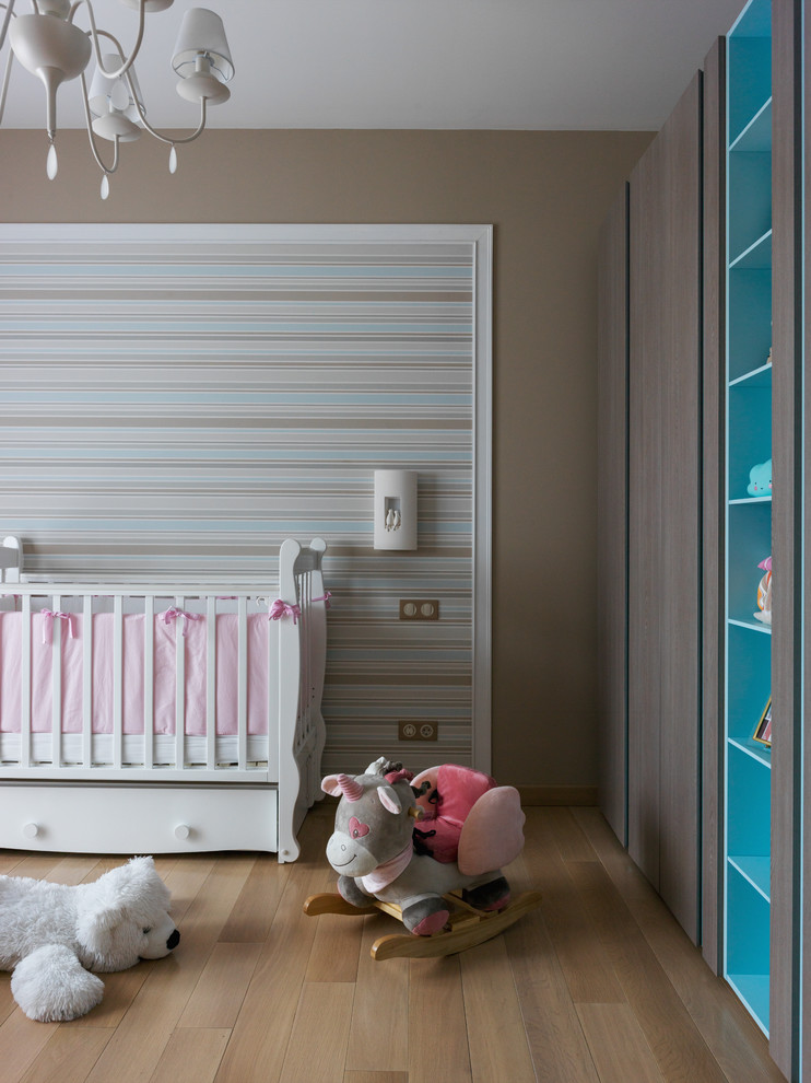 На фото: комната для малыша в современном стиле с коричневыми стенами, паркетным полом среднего тона и коричневым полом для девочки
