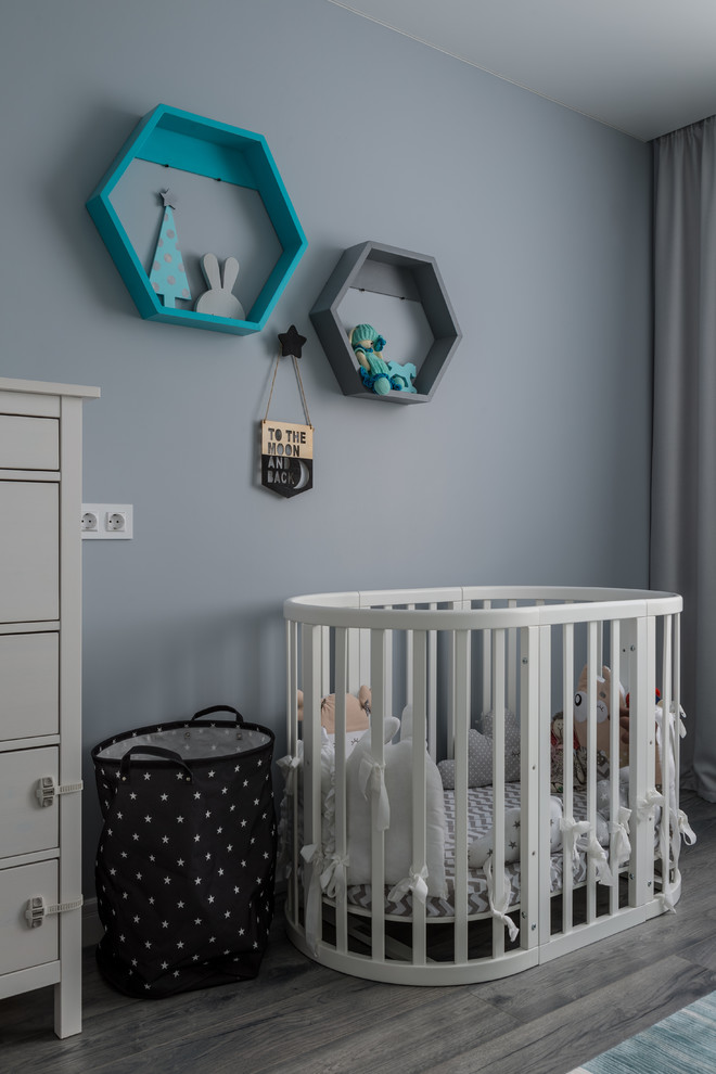 Diseño de habitación de bebé niño tradicional renovada con paredes azules y suelo gris