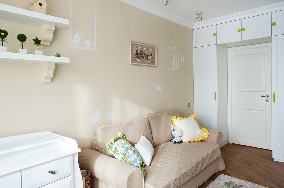 Inspiration pour une chambre de bébé design avec un mur beige et un sol en bois brun.