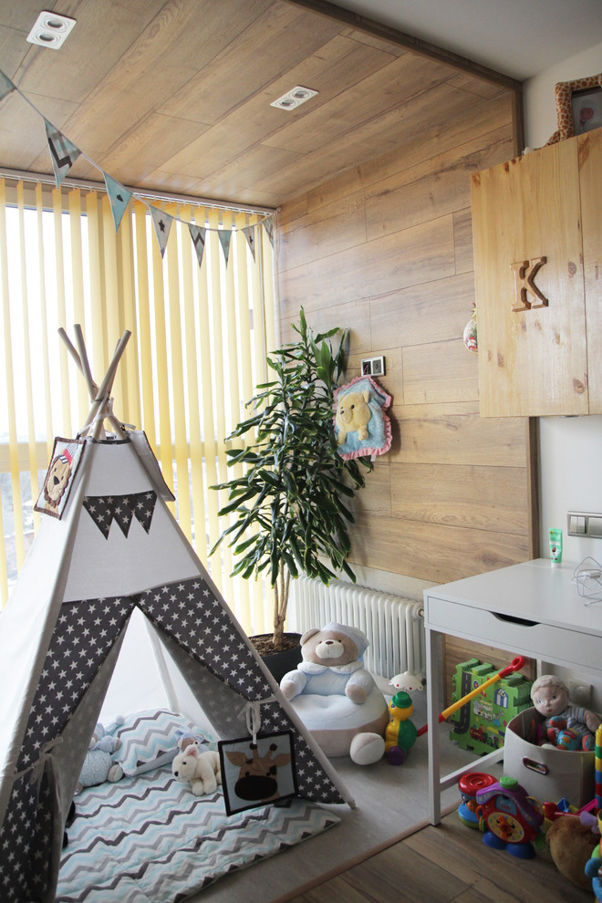 Immagine di una cameretta per neonato minimal di medie dimensioni con pareti bianche, pavimento in laminato e pavimento beige