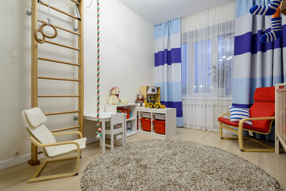 Exemple d'une chambre de bébé garçon tendance de taille moyenne avec un mur bleu, sol en stratifié et un sol beige.