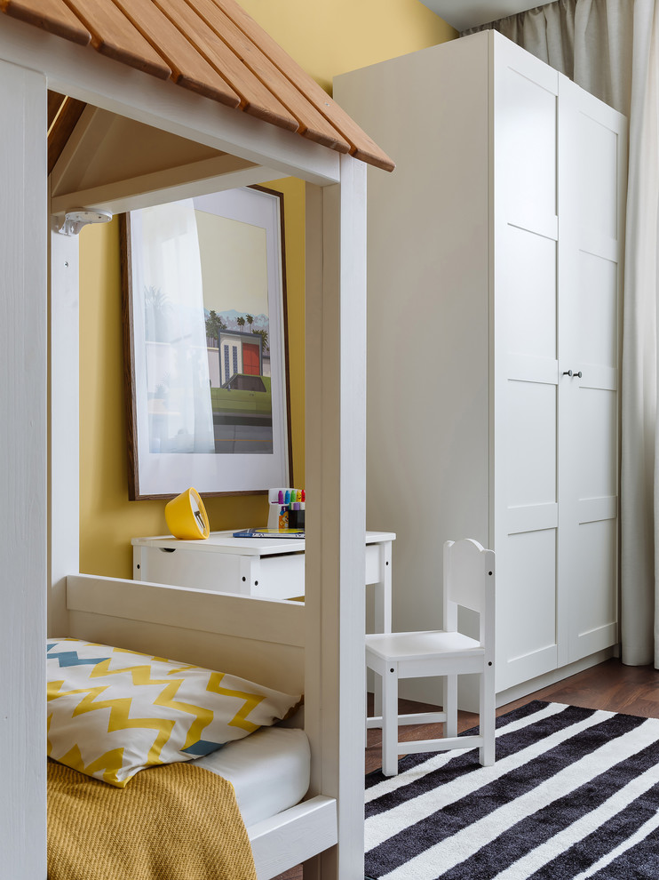 На фото: комната для малыша среднего размера в современном стиле с темным паркетным полом, коричневым полом и желтыми стенами для мальчика с