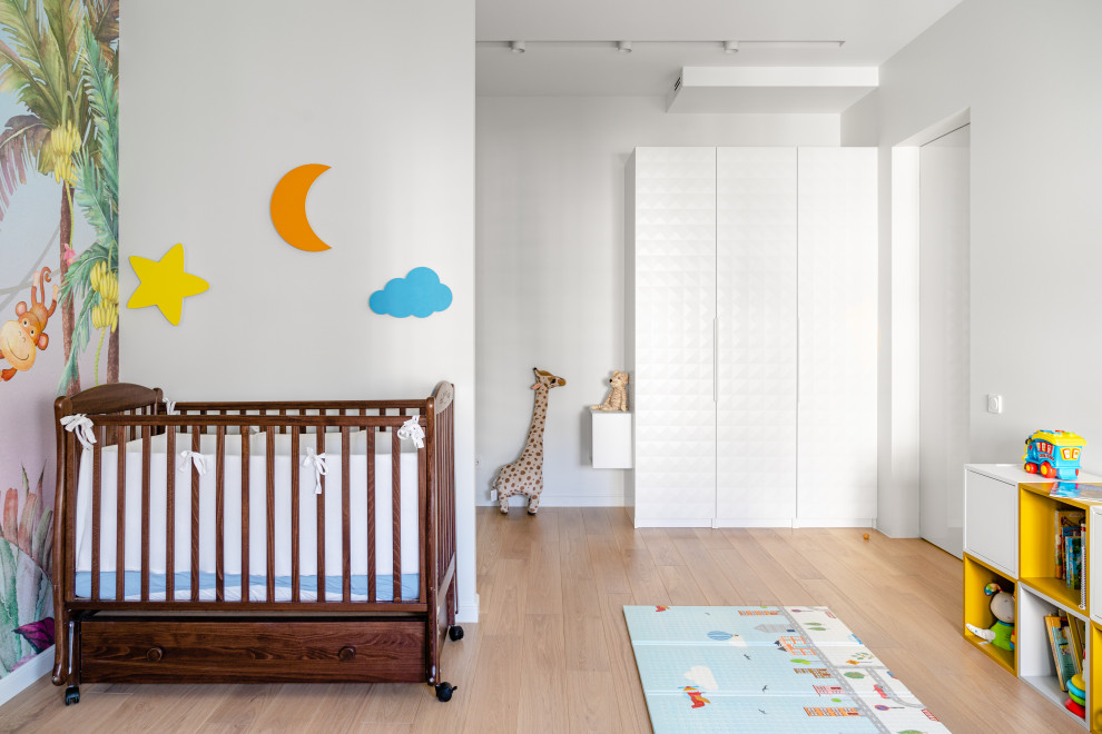 Пример оригинального дизайна: комната для малыша среднего размера в современном стиле с паркетным полом среднего тона и обоями на стенах для мальчика
