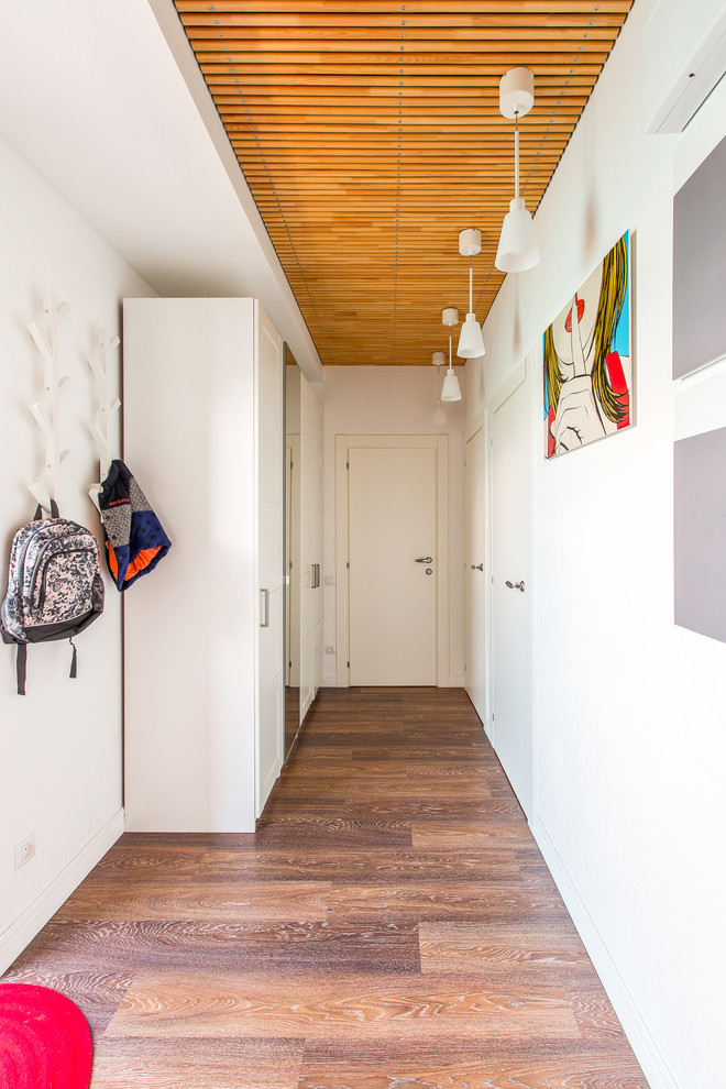 Foto de recibidores y pasillos contemporáneos con paredes blancas y suelo de madera en tonos medios