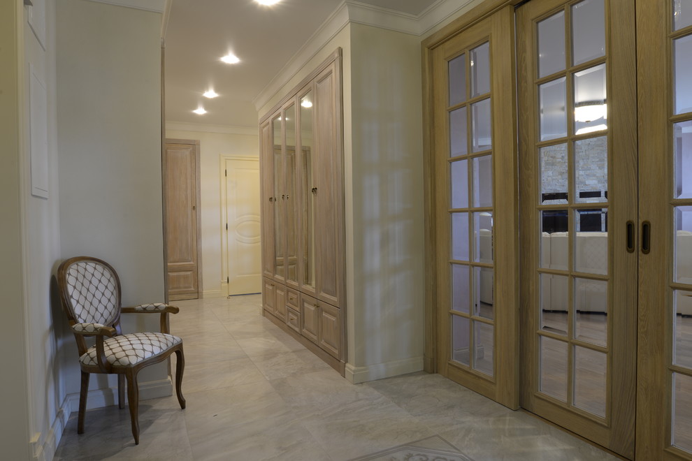 Ejemplo de recibidores y pasillos clásicos de tamaño medio con paredes beige, suelo de baldosas de porcelana y suelo gris