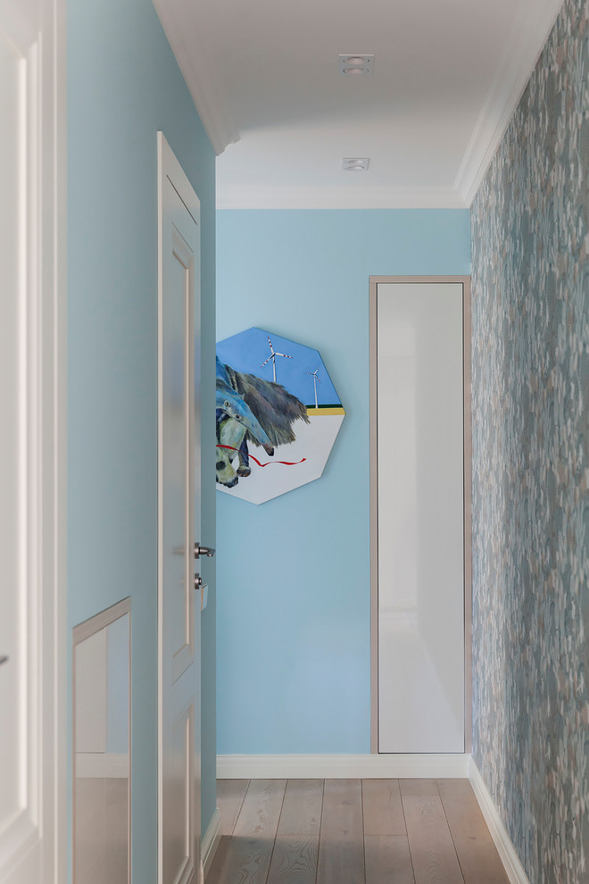 Cette photo montre un couloir scandinave avec un mur bleu, parquet clair et un sol beige.