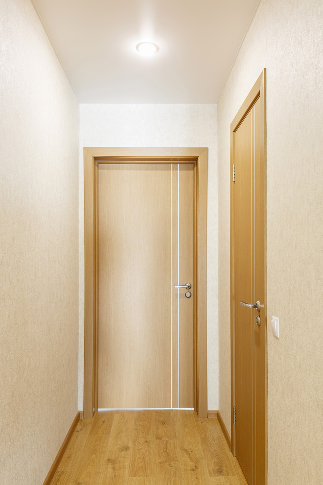 Idée de décoration pour un petit couloir design avec un mur beige, un sol en carrelage de porcelaine et un sol marron.