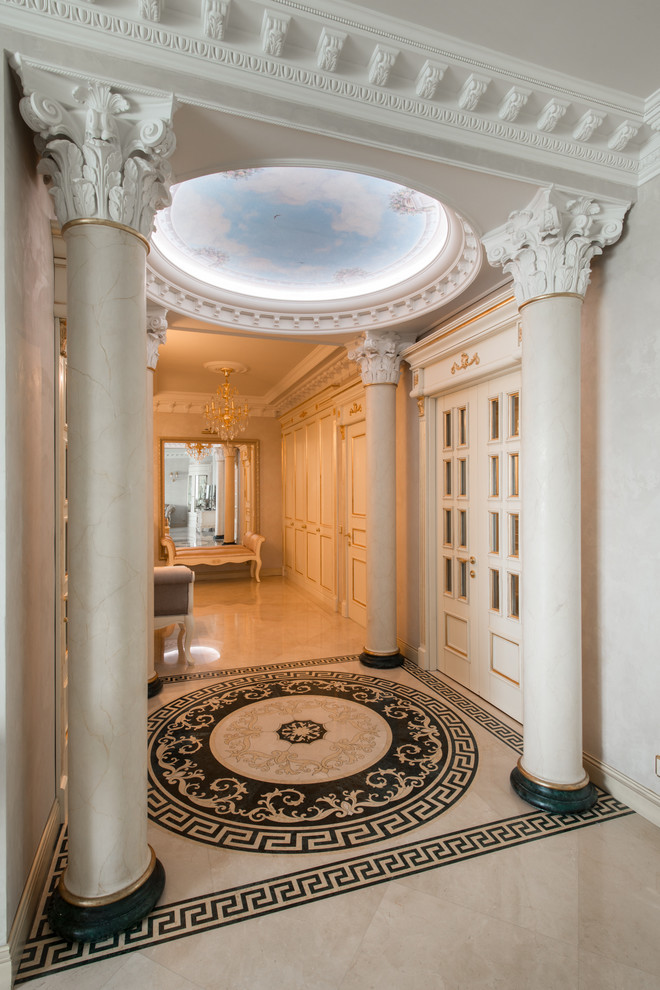 На фото: большой коридор в классическом стиле с белыми стенами и мраморным полом